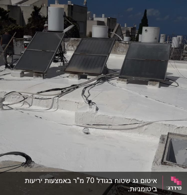 גג אטום בצבע לבן עם דליים ומברשות